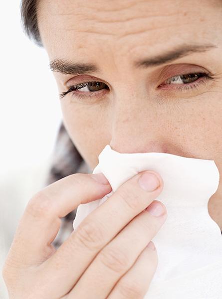 Vrouw snuit haar neus bij een verkoudheid